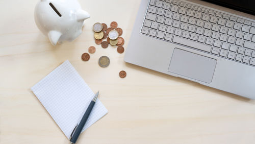Bureau met laptop, spaarpot en munten Bureau met laptop, spaarpot en munten