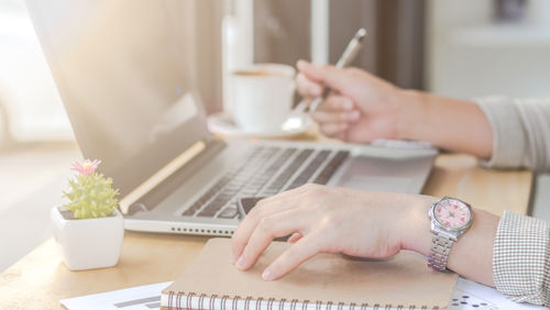 Mevrouw zit achter laptop met notitieboek erbij en ontdekt hoe een indicatie aanvragen Mevrouw zit achter laptop met notitieboek erbij en ontdekt hoe een indicatie aanvragen