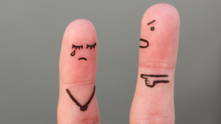 Twee vingers met getekende gezichten waarvan een verdrietig en een boos Twee vingers met getekende gezichten waarvan een verdrietig en een boos