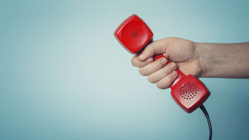 Rode vaste telefoon met blauwe achtergrond Rode vaste telefoon met blauwe achtergrond